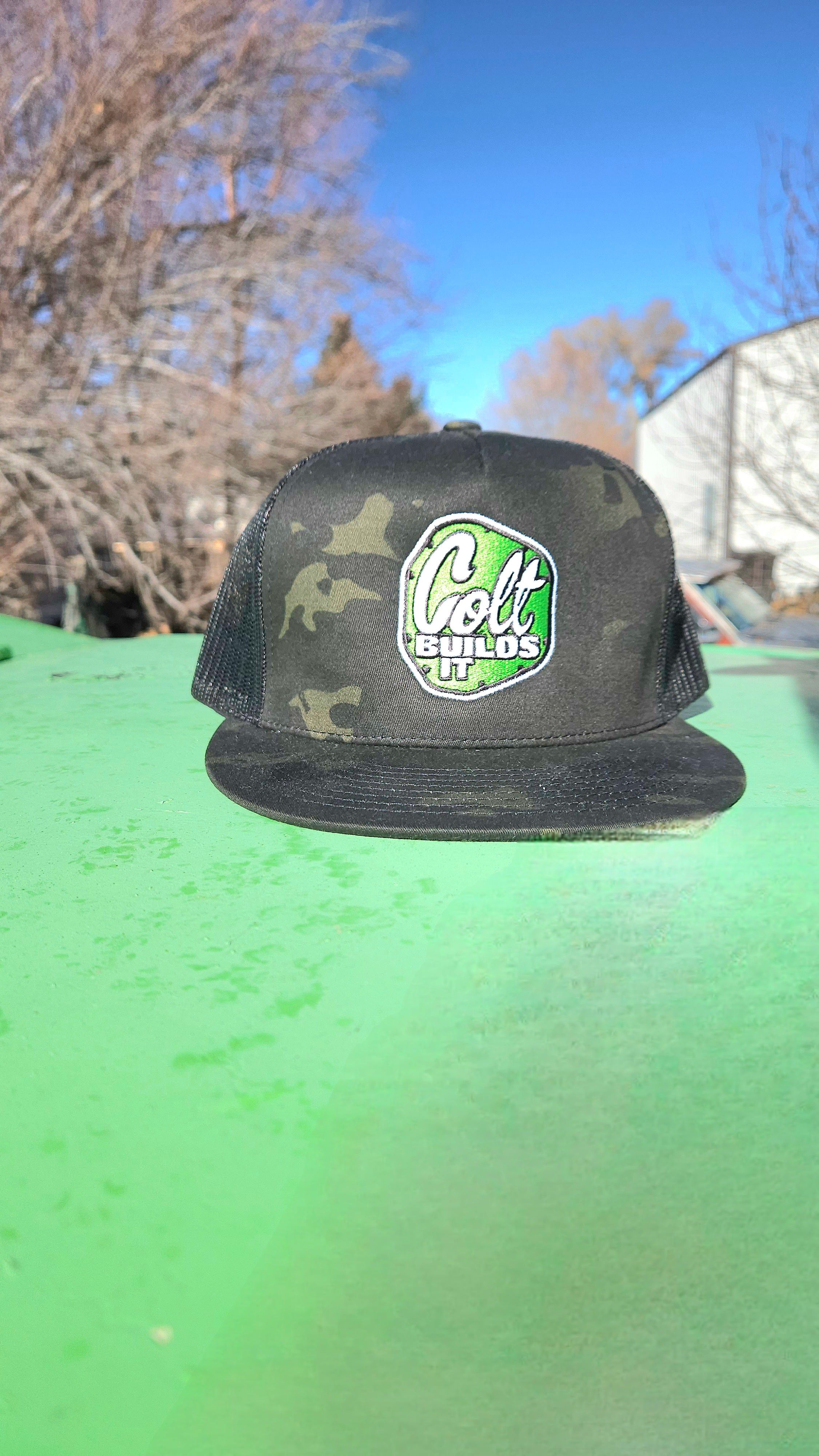 Colt Builds It dark camouflage trucker hat with embroidered logo worn on the trail