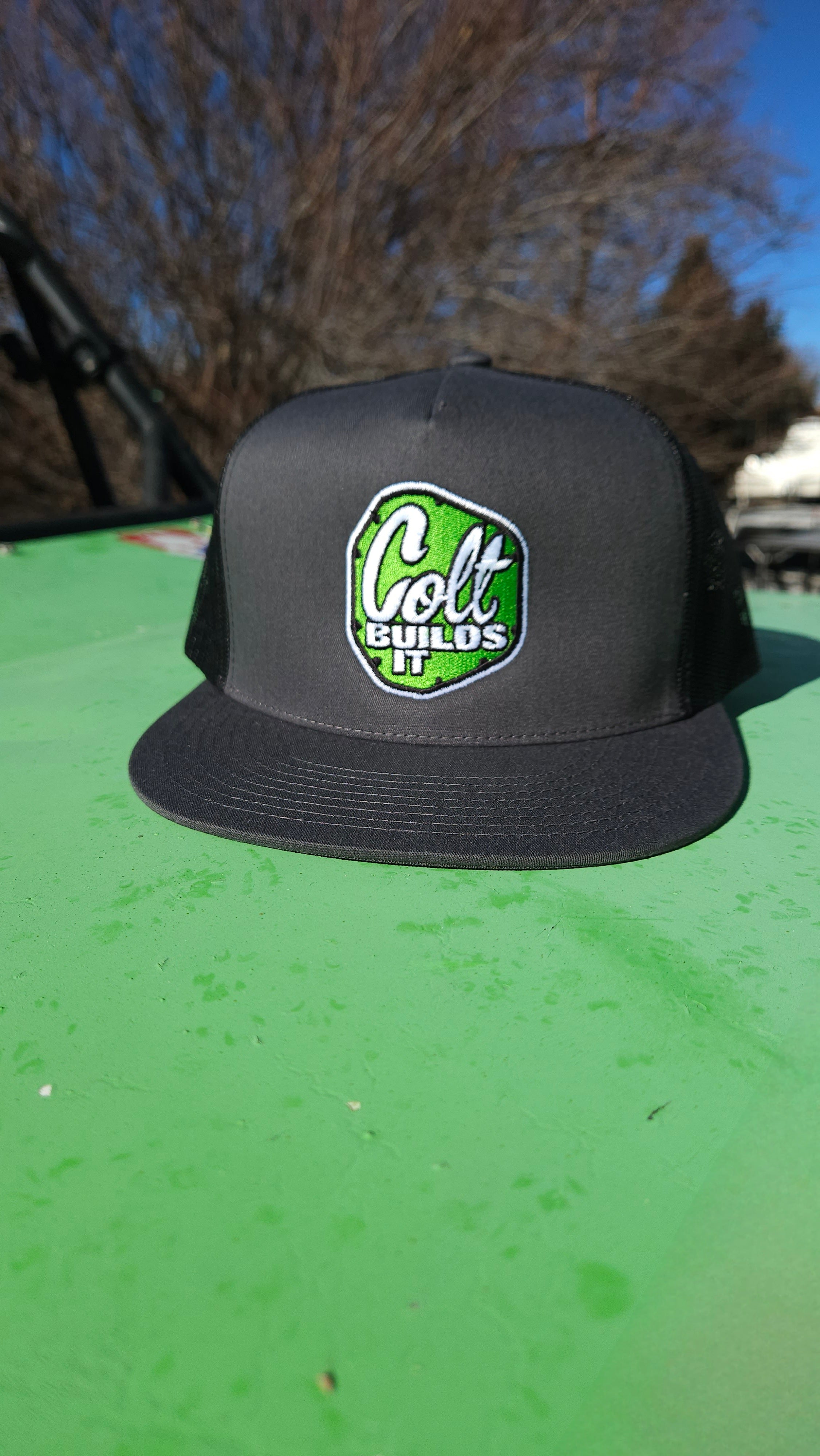 Colt Builds It dark grey trucker snapback hat with black mesh back and embroidered logo